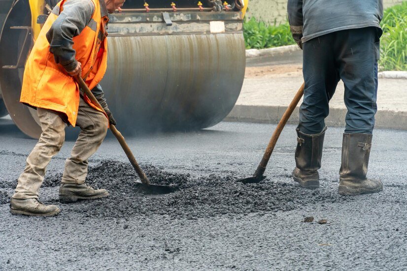 team-workers-with-shovels-is-working-laying-new-asphalt-road-repairs-workers-with-tools-roller-asphalt-stacker-road-during-work_678914-5441